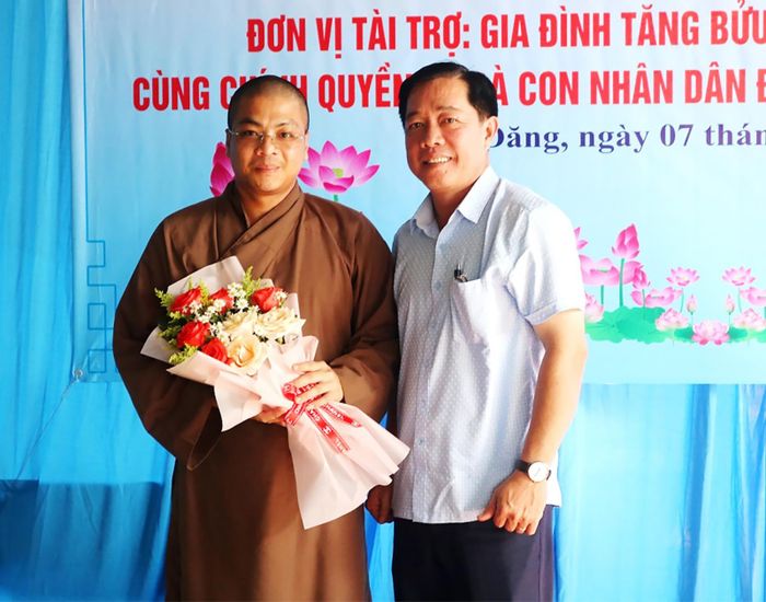 Bí thư Đảng ủy, Chủ tịch HĐND xã Cần Đăng Trần Tấn Phương tặng hoa và trao thư cảm ơn nhà hảo tâm tài trợ kinh phí xây cầu.