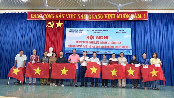 Đại diện Hải đoàn 21 và Ban Xây dựng Đảng, Đảng ủy xã Núi Thành trao quà và cờ Tổ quốc cho gia đình ngư dân có hoàn cảnh khó khăn. Ảnh: HẢI ĐĂNG