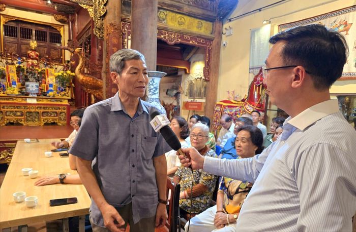 Đảng viên Đặng Gia Tùng, Chi bộ Tổ dân phố Hàng Bạc 2, phường Hoàn Kiếm trao đổi với phóng viên Cơ quan Báo và Phát thanh, Truyền hình Hà Nội. Ảnh: Công Thọ