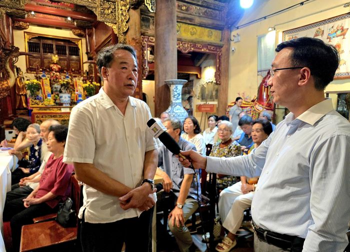 Bí thư Chi bộ tổ dân phố Hàng Bạc 2 Nguyễn Đức Lực, phường Hoàn Kiếm trao đổi với phóng viên Cơ quan Báo và Phát thanh, Truyền hình Hà Nội. Ảnh: Công Thọ