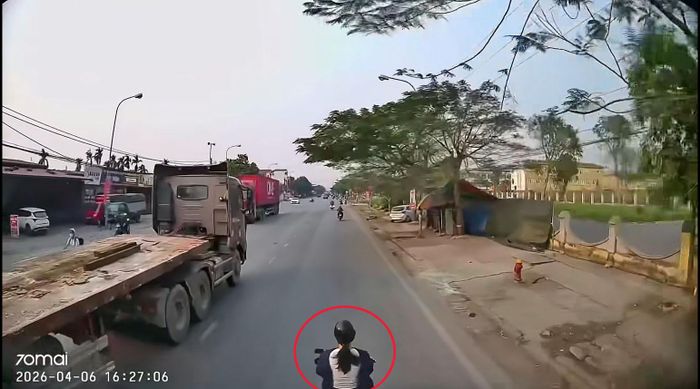 Hình ảnh chị Linh lái xe máy trước khi bị xe tải tông trúng. (Ảnh cắt từ clip)