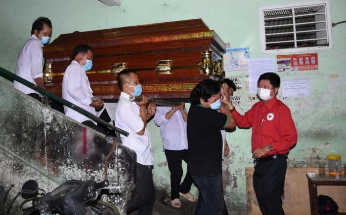 Ông Khoa (áo đỏ) trong một lần tổ chức mai táng miễn phí cho người nghèo. Ảnh: Nhân vật cung cấp