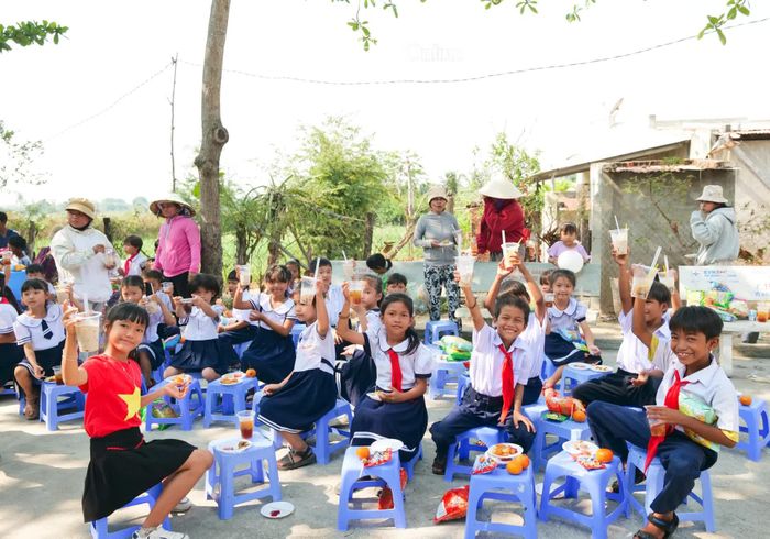  Học sinh Trường Tiểu học Nhơn Sơn A phấn khởi thưởng thức đồ ăn, thức uống từ các gian hàng “0 đồng”. 