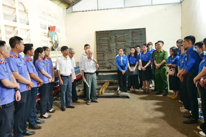 Đoàn viên, thanh niên lắng nghe cán bộ lão thành kể chuyện, giới thiệu về lịch sử di tích Đề pô xe lửa Tháp Chàm.