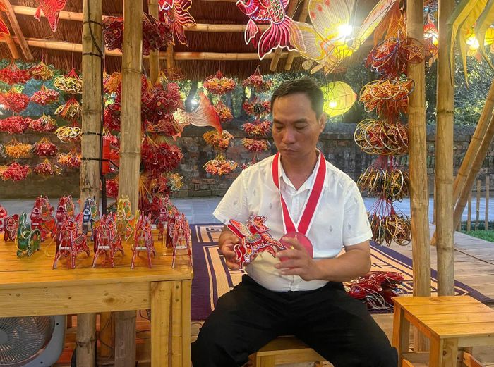 Nghệ nhân Nguyễn Trọng Bình, đại diện cơ sở đèn lồng Trọng Bình Cổ Đăng (TP.HCM) cùng những sản phẩm của mình. Ảnh: Thanh Bình