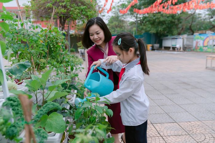 Cô và trò trường Tiểu học Đô Thị Việt Hưng (phường Việt Hưng) cùng nhau tưới nước.