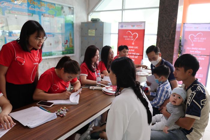 Cán bộ, nhân viên Viettel Lai Châu hướng dẫn nhân dân làm thủ tục khám sàng lọc miễn phí bệnh tim bẩm sinh cho trẻ.