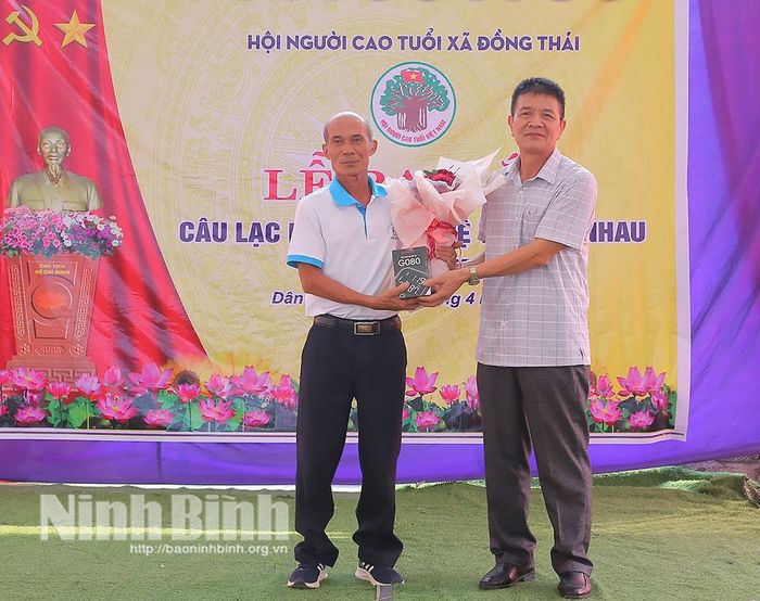 Lãnh đạo Hội Người cao tuổi tỉnh tặng hoa chúc mừng CLB liên thế hệ tự giúp nhau thôn Dân Mới.