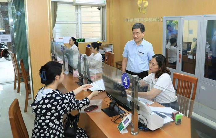 Lãnh đạo phường Cửa Nam giám sát việc giải quyết thủ tục hành chính cho người dân tại điểm phục vụ hành chính công. Ảnh: Quang Thái