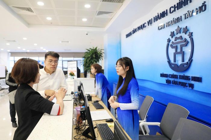 Hỗ trợ người dân giải quyết thủ tục hành chính trực tuyến tại Trung tâm Phục vụ hành chính công chi nhánh Tây Hồ. Ảnh: Quang Thái