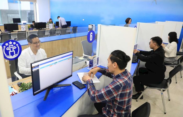 Hỗ trợ người dân giải quyết thủ tục hành chính trực tuyến tại Trung tâm Phục vụ hành chính công chi nhánh Tây Hồ. Ảnh: Quang Thái