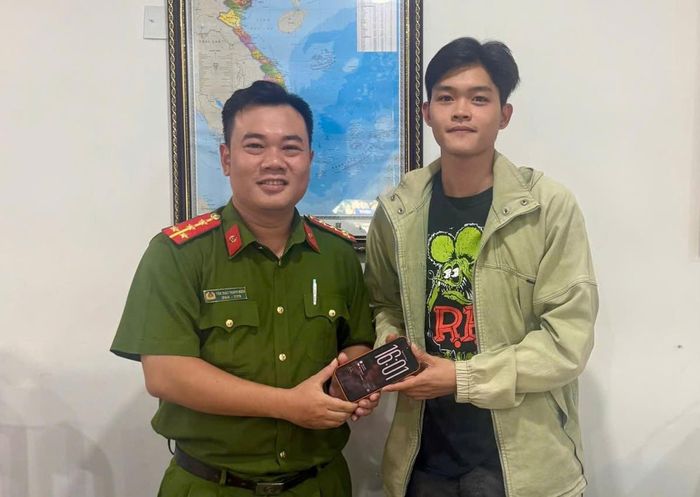 Cán bộ Đồn Công an CHKQT Đà Nẵng trao trả chiếc ĐTDĐ cho anh Long.