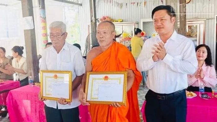 Đồng chí Trần Minh Thới, Phó Bí thư Đảng ủy, Chủ tịch Ủy ban nhân dân xã Vĩnh Mỹ, tặng quà và giấy khen cho các vị sư trụ trì các chùa, các cá nhân là người Khmer có uy tín tại địa phương.