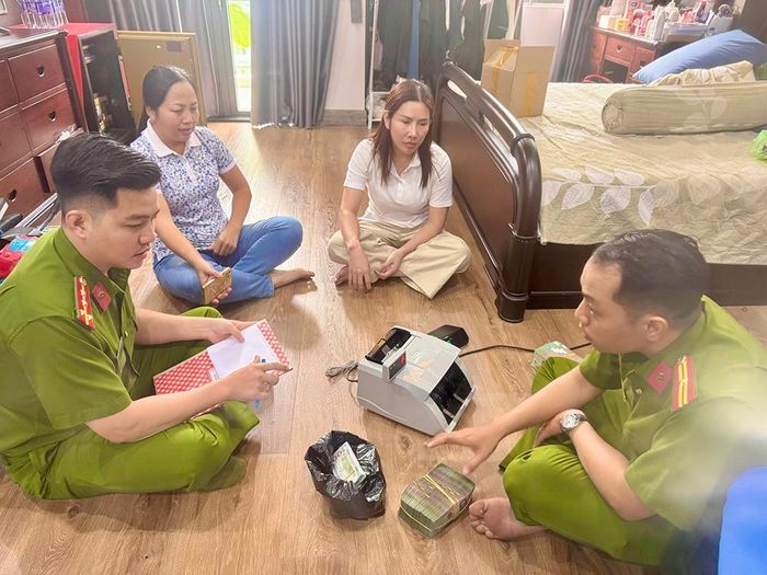 Công an khám xét, thu giữ tiền mặt và nhiều vật chứng tại nơi ở của Lê Thị Thùy Trang. Ảnh: CA.