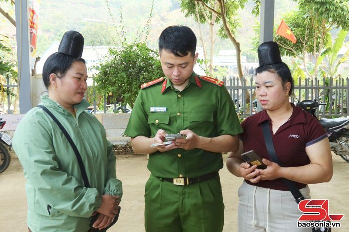 Cán bộ Công an phường Chiềng Cơi hướng dẫn nhân dân bản Hùn thực hiện thủ tục hành chính, tích hợp giấy tờ trên ứng dụng VNeID.