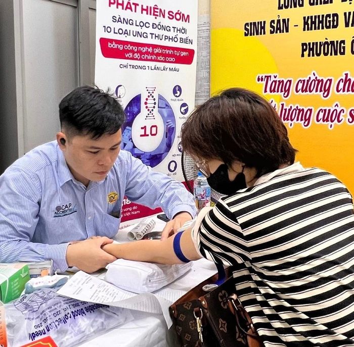 Cán bộ y tế tư vấn, lấy mẫu xét nghiệm cho người dân trong chiến dịch chăm sóc sức khỏe sinh sản tại phường Ô Chợ Dừa. Ảnh: P.V