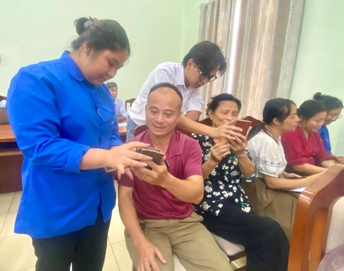 Lực lượng đoàn viên thanh niên hỗ trợ phổ cập kỹ năng số cho các cán bộ thôn trên địa bàn. Ảnh: Hoàng Quyết