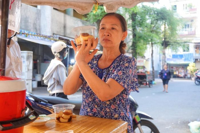  Bà Mười đang đóng gói bánh flan cho khách mang đi. Ảnh: Mộc Khải. 