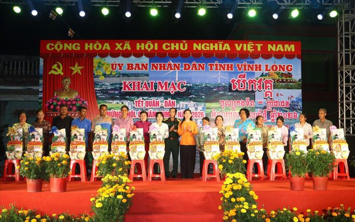 Ban tổ chức trao quà cho các hộ gia đình tại địa phương. Ảnh: Lê Thúy Hằng – TTXVN