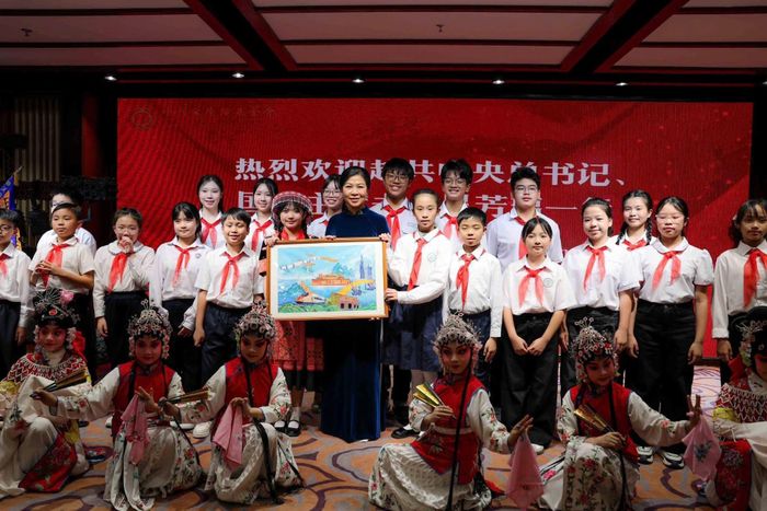 Phu nhân Ngô Phương Ly tặng quà cho các học viên của Trung tâm đã biểu diễn tiết mục “Mộc Quế Anh quải soái”. Đội hình thiếu nhi Việt Nam tham gia Hành trình Đỏ tại Bắc Kinh cũng góp mặt trong một tiết mục. Ảnh: TTXVN