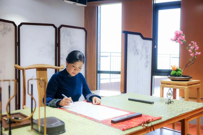 Phu nhân Ngô Phương Ly viết lưu bút tại Trung tâm giao lưu khoa học văn hóa thanh thiếu niên Tống Khánh Linh. Ảnh: TTXVN