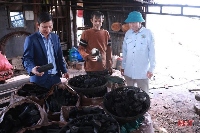 Ông Lê Sinh (ngoài cùng bên phải) cùng cán bộ phường Vũng Áng kiểm tra khu sản xuất than củi của anh Nguyễn Văn Hải (ở giữa).