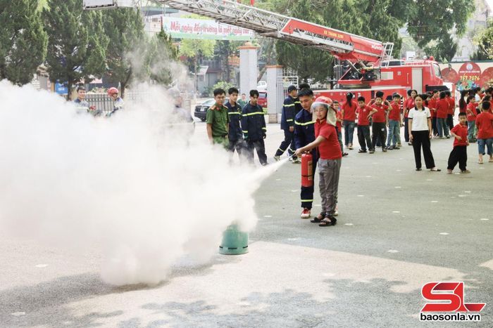 Học sinh thực hành sử dụng bình chữa cháy.