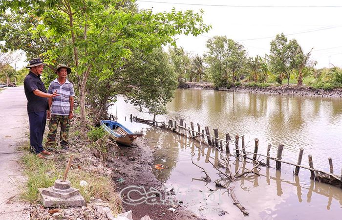 Bí thư chi bộ Tô Hoàng Vũ (bìa trái) cho biết nhiều tuyến lộ tại ấp Tân Phú đang đối mặt nguy cơ sạt lở, sẽ được gia cố bằng bờ kè từ mô hình hùn vốn.