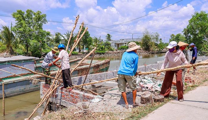 Các lực lượng địa phương và hội viên phụ nữ chung tay xây dựng bờ kè chống sạt lở.