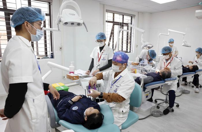 Bác sĩ Bệnh viện Đại học Y Hà Nội khám bệnh cho người dân tại Trạm Y tế phường Vĩnh Hưng. Ảnh: Như Ý
