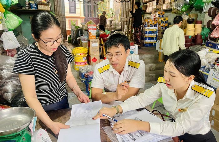 Cán bộ Thuế cơ sở 24 thành phố Hà Nội hướng dẫn hộ kinh doanh thực hiện quy định về thuế. Ảnh: Nga Nguyễn