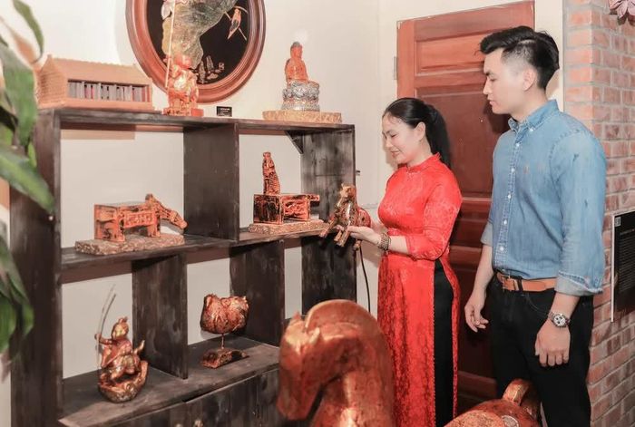 Nghệ nhân Trần Thị Thúy Hường, chủ cơ sở sơn mài Phúc Cường (xã Hồng Vân, Hà Nội) giới thiệu các sản phẩm sơn mài tới du khách tại buổi trưng bày. Ảnh: Phan Phuơng - TTXVN