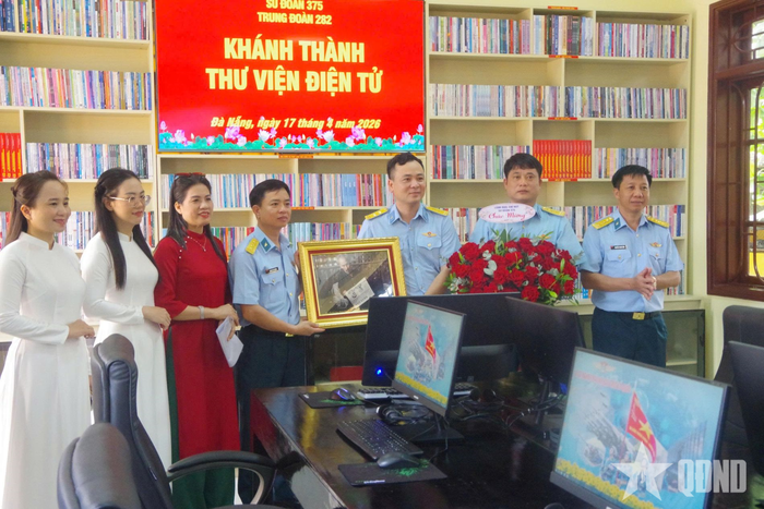 Đại tá Hoàng Phi Trường, Phó chính ủy Sư đoàn (thứ 4 từ trái sang) và Đại tá Nguyễn Thanh Bình, Chủ nhiệm Chính trị Sư đoàn (ngoài cùng bên phải) tặng tranh và hoa chúc mừng khánh thành Thư viện điện tử Trung đoàn Tên lửa 282.