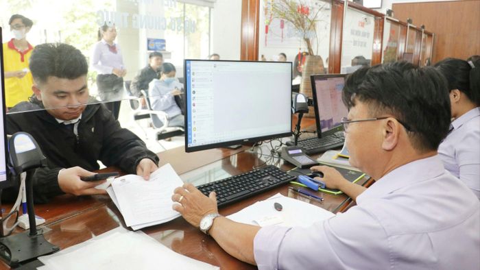  Công chức Trung tâm Phục vụ hành chính công phường Thới An (TPHCM) hướng dẫn người dân làm thủ tục hành chính. ẢNH: NGÔ BÌNH 