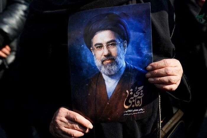  Một người dân Iran xuống đường cầm theo bức ảnh chân dung ông Mojtaba Khamenei. Ảnh: Reuters. 