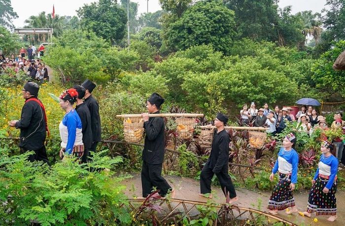 Đi đầu đoàn nhà trai là ông Mơ, tay nâng mâm trầu cau - sính lễ thiêng liêng mở đầu cho câu chuyện trăm năm, theo sau là chú rể cùng gia đình mang theo lễ vật sang nhà gái xin cưới. Ảnh: Khánh Hòa - TTXVN