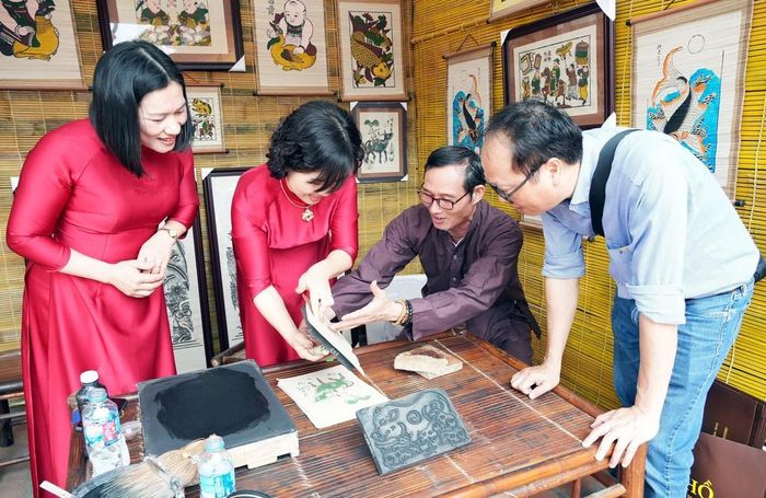 Du khách trải nghiệm in tranh dân gian Đông Hồ (Bắc Ninh). Ảnh: Đồng Thúy - TTXVN
