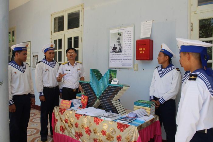 Cán bộ, chiến sĩ đảo Sơn Ca bên mô hình sách và những cuốn sách hay.