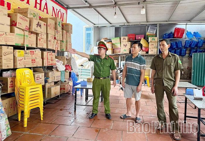 Cán bộ Công an xã Tam Hồng hướng dẫn chủ cơ sở sắp xếp hàng hóa, đảm bảo an toàn sử dụng điện.
