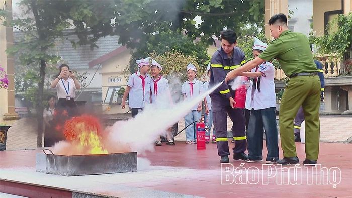 Cán bộ Phòng cảnh sát PCCC và CNCH, Công an tỉnh hướng dẫn học sinh cách sử dựng bình chữa cháy xách tay và thực hành chữa cháy.