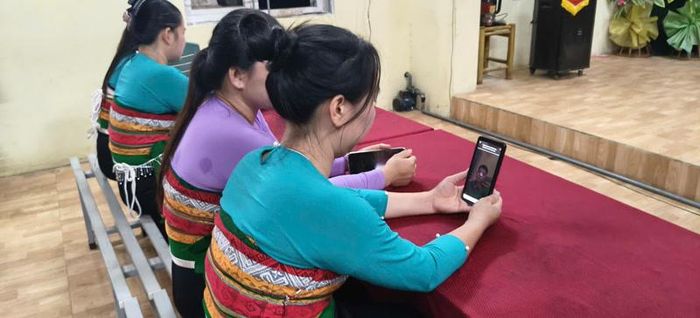 Người dân thôn Poọng, xã Văn Nho đang xem Công an xã Văn Nho livestream trực tiếp ở nhà văn hóa.
