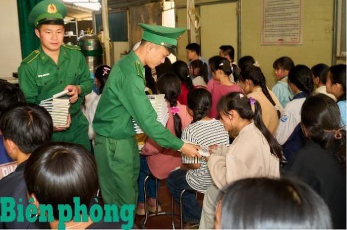Các chiến sĩ đồn Biên phòng Sì Lờ Lầu đồng hành trao tặng sách quý, dụng cụ học tập cho các em học sinh trường Trung học cơ sở Sì Lờ Lầu. Ảnh: Xuân Hương