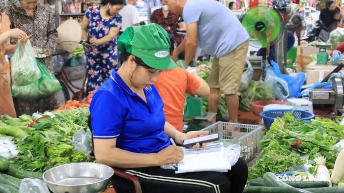 Tiểu thương ghi chép thông tin hàng hóa nhập vào theo từng ngày.