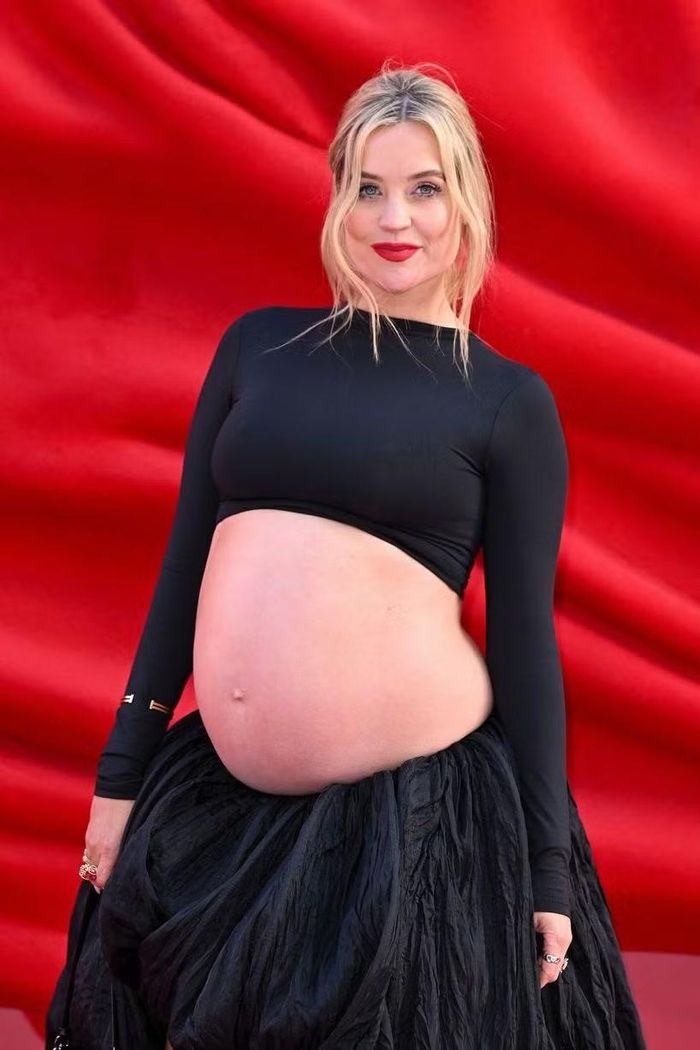 Laura Whitmore ôm bụng bầu, diện áo crop top đen và chân váy đến buổi công chiếu phim. Ảnh: Getty.