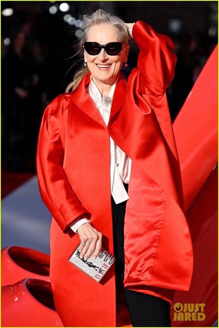 Về phụ kiện, Streep đeo trang sức của Fred Leighton, bao gồm nhẫn kim cương và khuyên tai dài cùng chiếc trâm cài hình ngôi sao ghim ở đường viền cổ áo. Bà hoàn thiện diện mạo của mình với cặp kính mắt mèo màu đen và giày cao gót đỏ, cả hai cũng đều đến từ Prada. Ảnh: Just Dared.