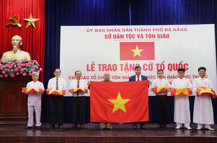 Giám đốc Sở Dân tộc và Tôn giáo Nguyễn Mạnh Hà (thứ 4, bên phải sang) trao cờ Tổ quốc cho các đơn vị, cơ sở tôn giáo, tín ngưỡng. Ảnh: HOÀNG LIÊN