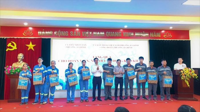 Chủ tịch Ủy ban MTTQ phường Ba Đình Võ Hồng Vinh (áo trắng) trao quà cho người lao động. Ảnh: Ngọc Đức