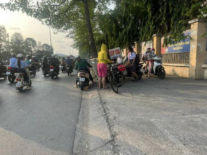 Học sinh và người dân mua thức ăn bày bán trước cổng Trường THCS Nguyễn Trãi.