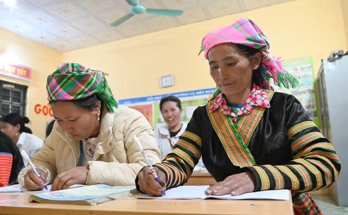 Chị Sồng Thị Ly (bên phải ảnh), 48 tuổi, học viên cao tuổi nhất đã chủ động đăng ký tham gia lớp xóa mù chữ tại bản.