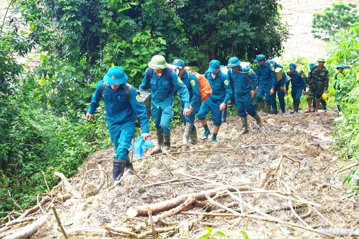 Dân quân gùi lương thực, thực phẩm tiếp tế cho người dân vùng lũ Mường Pồn năm 2024 (ảnh tư liệu).